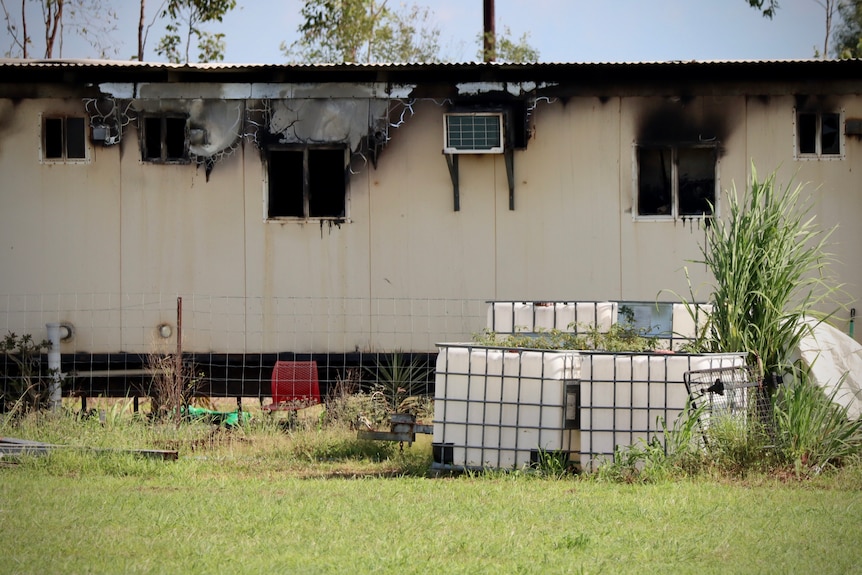 A house with obvious burn marks can be seen. It is a simple structure.