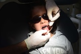 A young child has their teeth examined