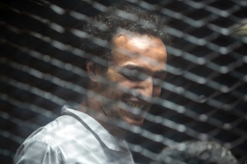 Mahmoud Abu Zeid stands inside a cage in an Egyptian Court in Cairo