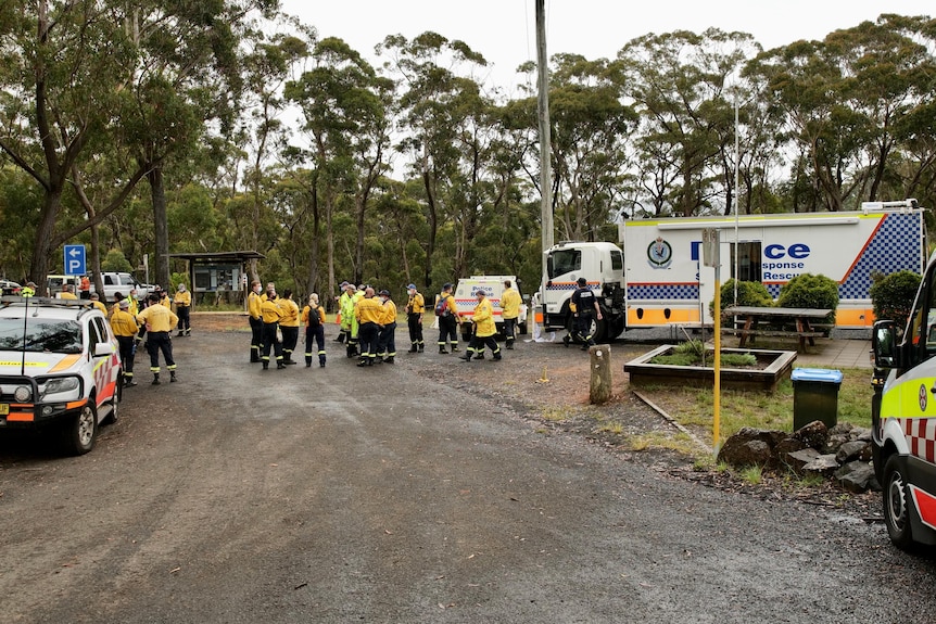 members of the RFS gathering in the wet wilderness surrounded by emergency vehicles