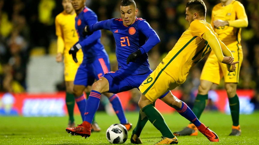 Colombia's Mateus Uribe duels for the ball with Australia's Josh Risdon at Craven Cottage stadium in London.