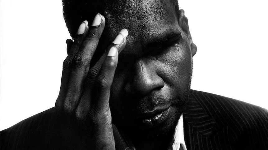 Close-up, black and white photo of Gurrumul with his head in his hands