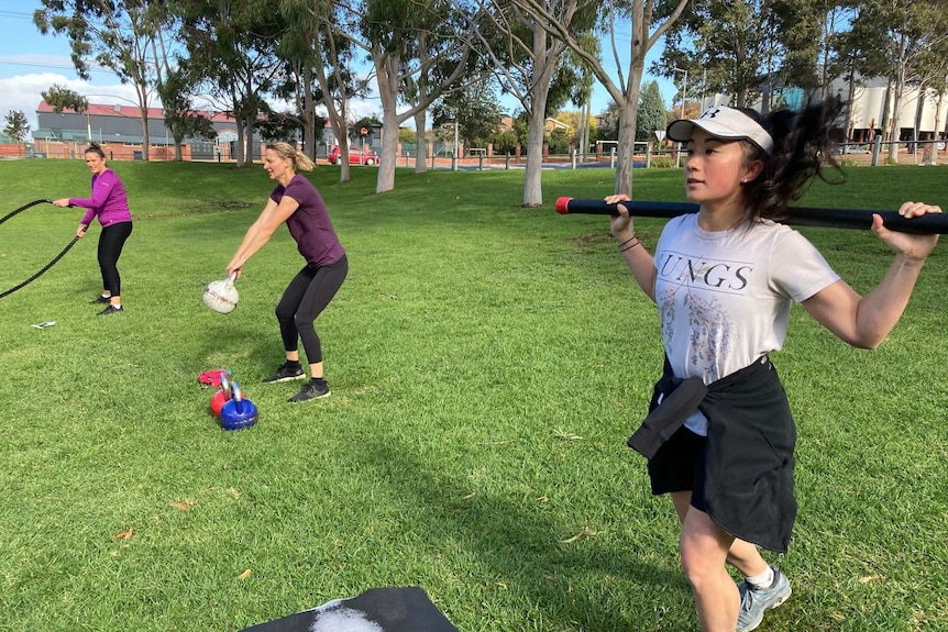 Three women working out in a park.