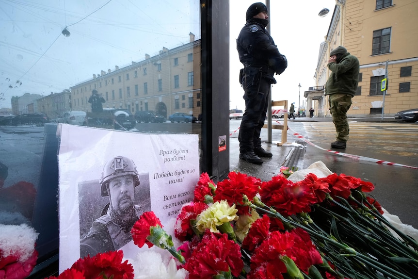 Flowers and a poster with a photo of blogger Vladlen Tatarsky placed near the site of an explosion.