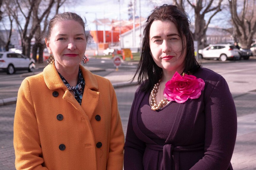Picture of a woman in a yellow coat and a woman in purple outside in Hobart.