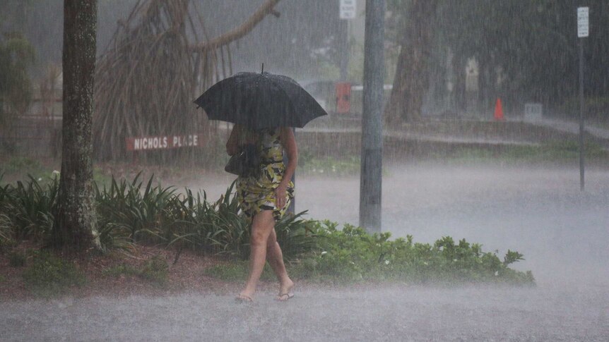 A woman gets caught in a heavy storm in Darwin's CBD