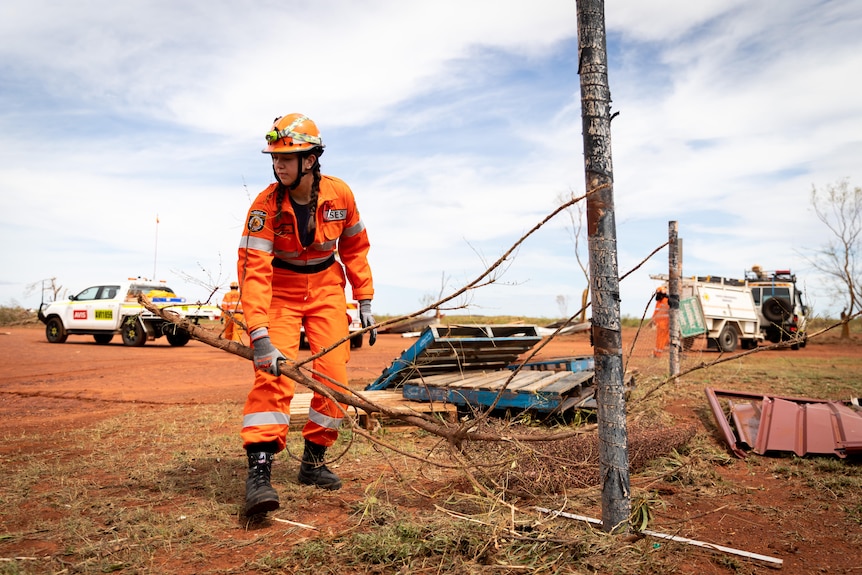 An SES worker removing debris from the cyclone.