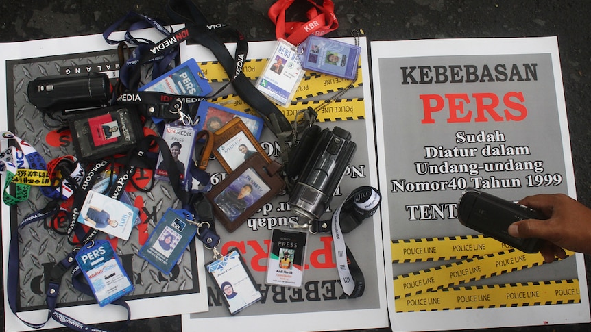 Dozens of journalists' ID cards on paper with the words 'Press Freedom is Regulated in the Press Law'