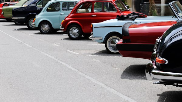 a row of parked vintage cars on tarmac