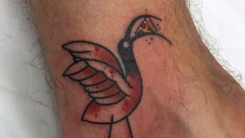 A photo of a tattoo on a man's ankle, the tattoo is of a cartoon ibis