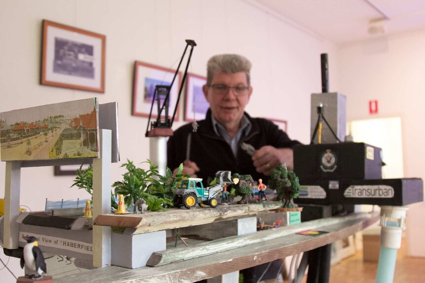 Chris Elenor stands behind his diorama using heritage materials