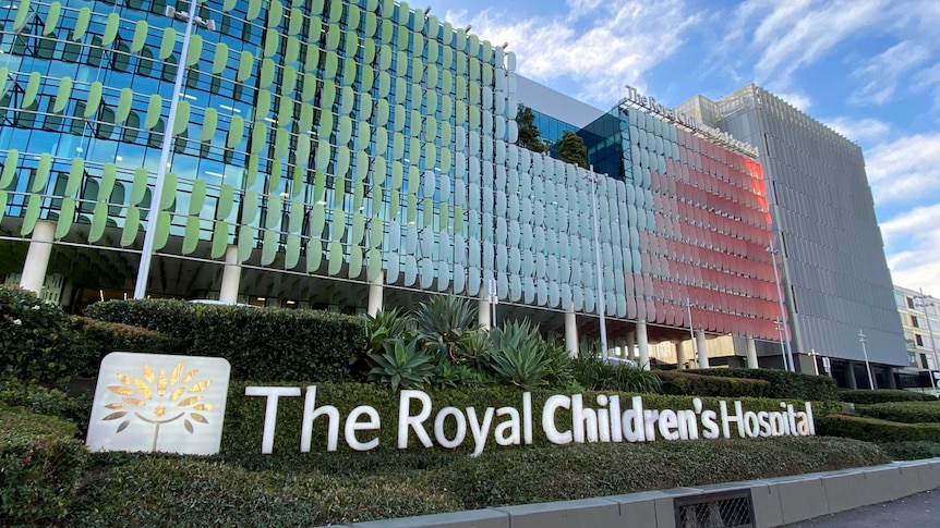 A sign saying "The Royal Children's Hospital" sits in a garden in front of one of the facility's large, colourful buildings.