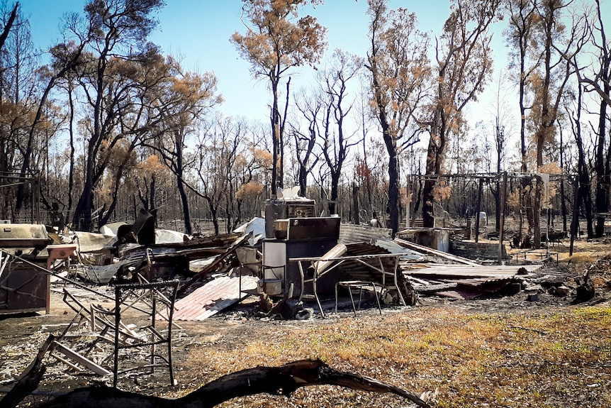 A pile of fire-damaged rubble in burnt bushland.