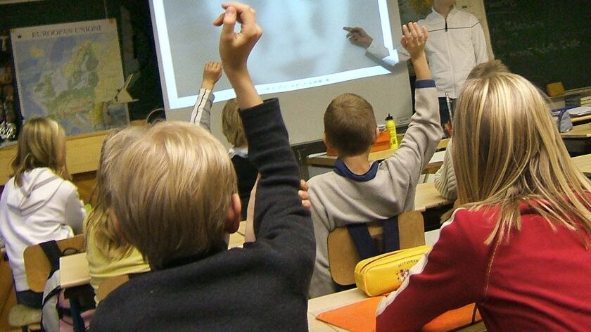 Primary school students raise their hands in the classroom (www.flickr.com: Juska Wendland, file photo)