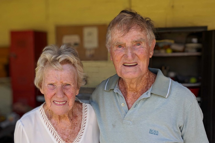 An old man and woman pose for the camera