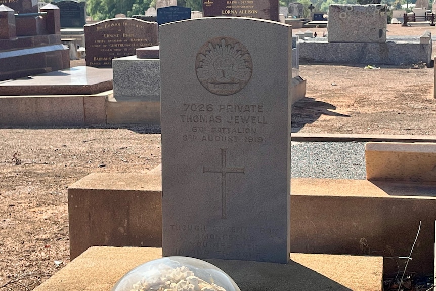 Headstone with the rising sun emblem and the words 7026 Private Thomas Jewell