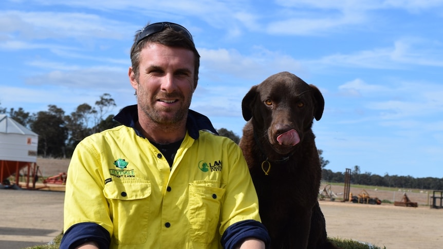 Anthony Snow (pictured with his dog) on a turf farm in East Gippsland, near Meerlieu.