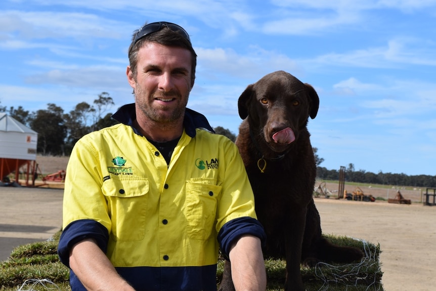 Anthony Snow (pictured with his dog) on a turf farm in East Gippsland, near Meerlieu.