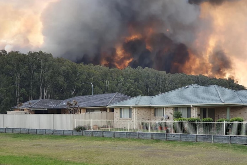 Flames and smoke behind houses