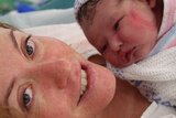 Amy Dawes holds her baby in the maternity ward