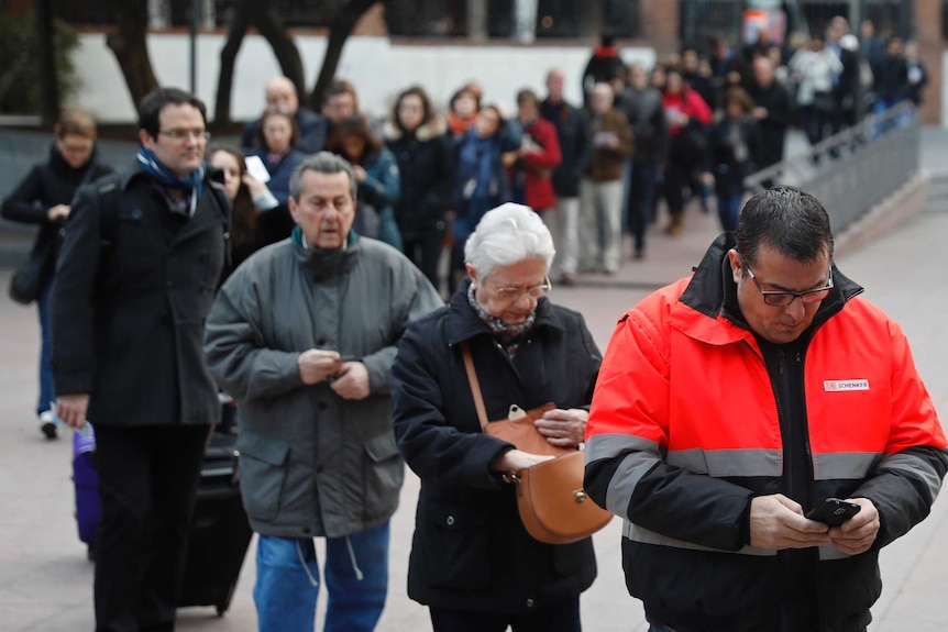 A long queue of people waiting to cast their vote for the Catalan regional election.