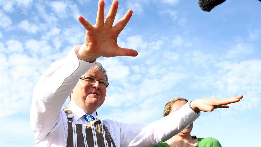 Kevin Rudd stands in front of a barbeque at The Entrance.