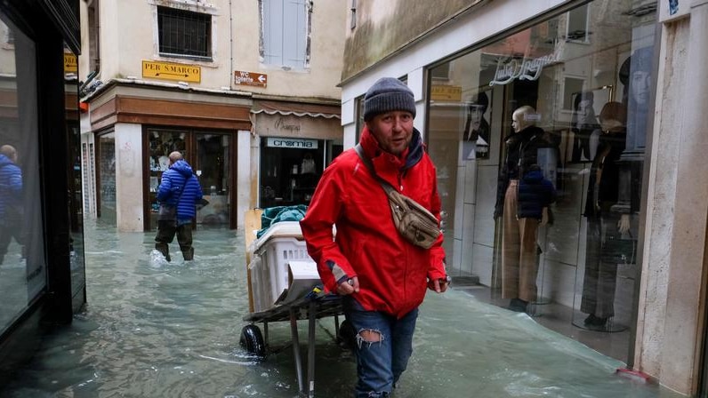 A man walks outside during exceptionally high water levels in Venice.