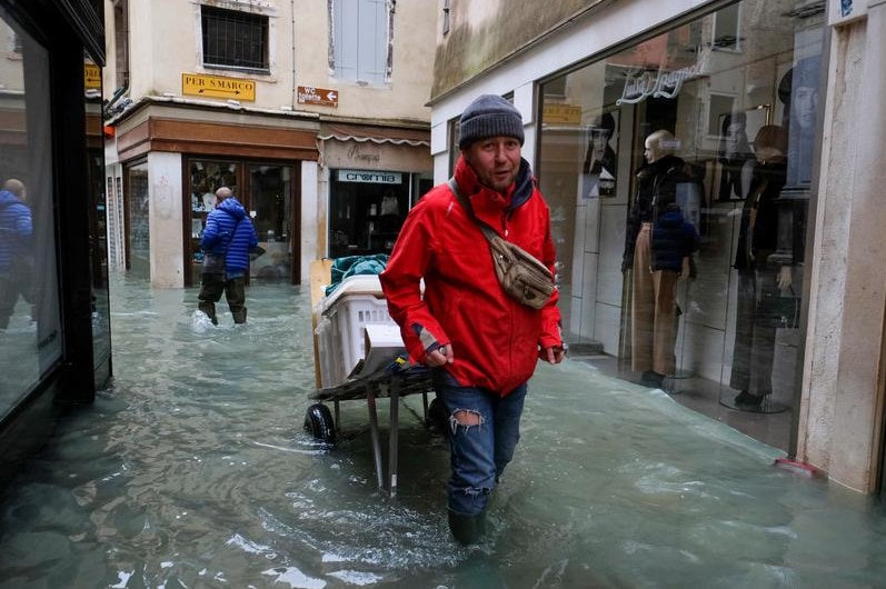 A man walks outside during exceptionally high water levels in Venice.