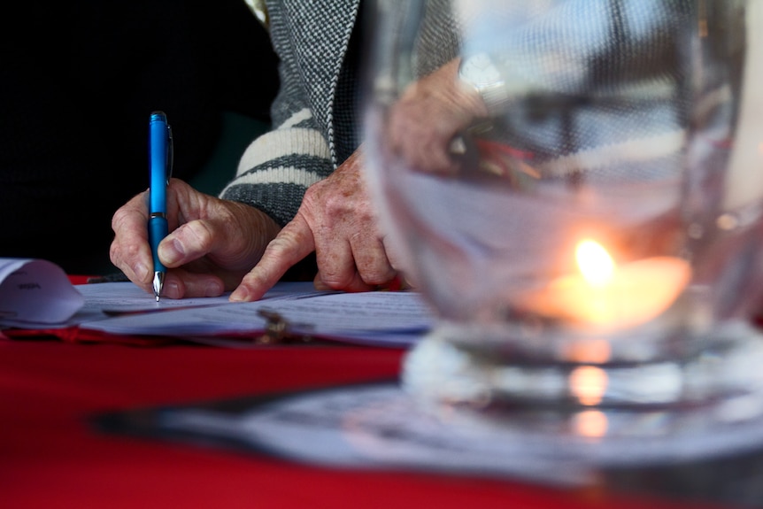 Hand signing a petition by candlelight