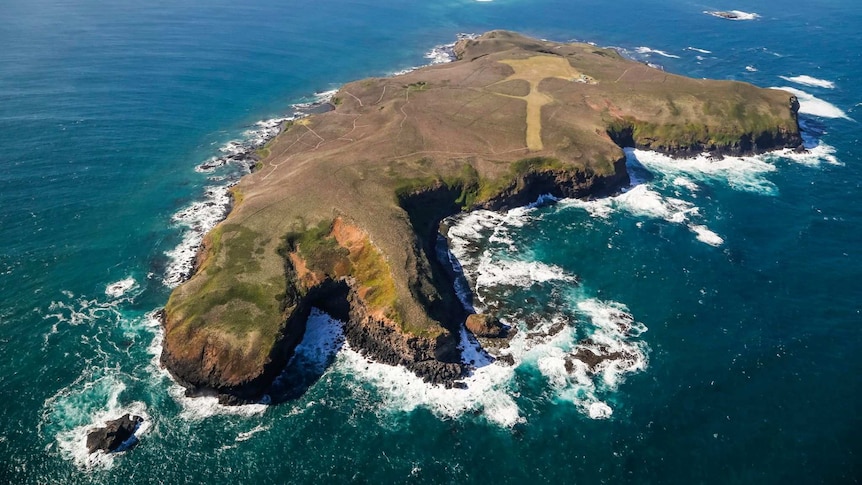 Aerial view of a small island with rocky outcrop.