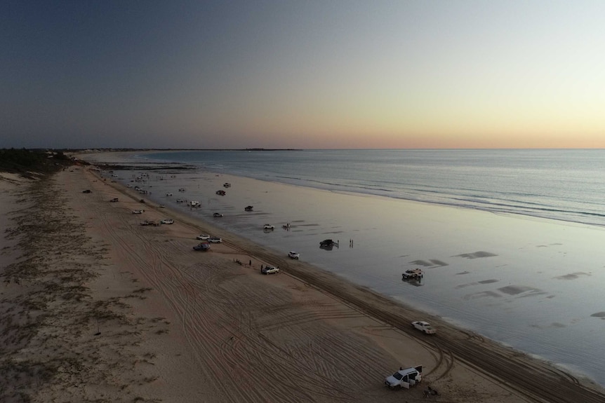 An aerial shot of a wide northern Australian beach at dusk.