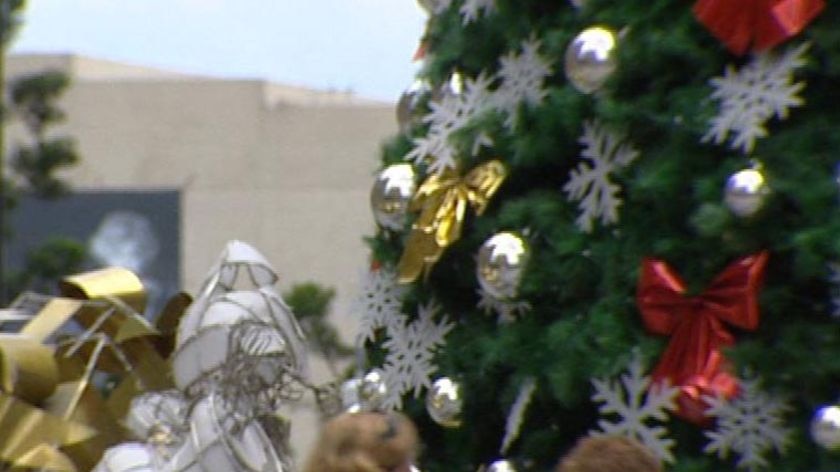 Generic TV still of people walking in Brisbane with Christmas decorations in the street