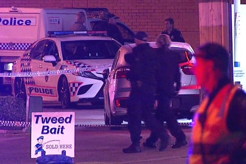 Police cars and officers on the forecourt of a petrol station