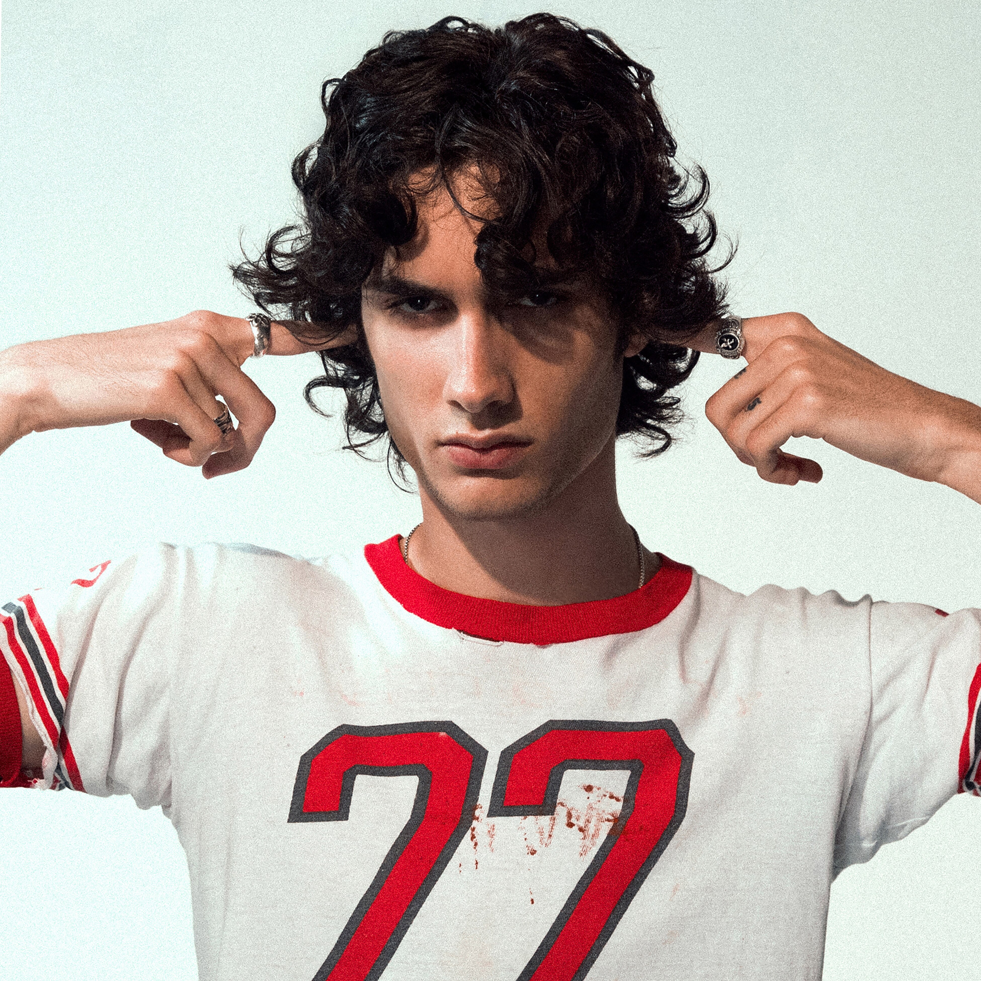 Photo of sombr with his fingers blocking his ears