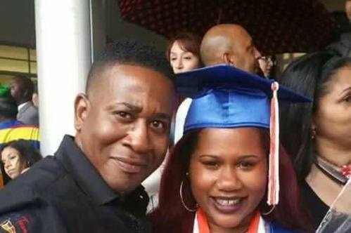 Orlando shooting victim Paul Terrell Henry posing for a photo with a girl in a graduation gown, believed to be his daughter