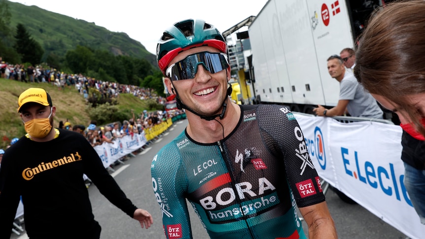 Australian cyclist Jai Hindley looks in the camera with a beaming smile after winning a Tour de France stage.