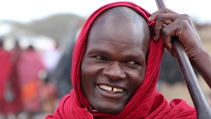 A masai man standing with a spear and club