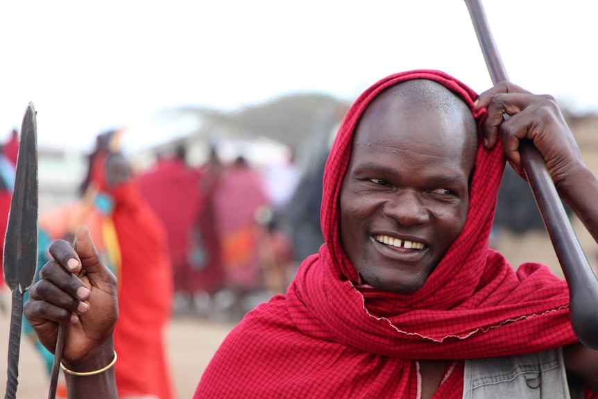 A masai man standing with a spear and club