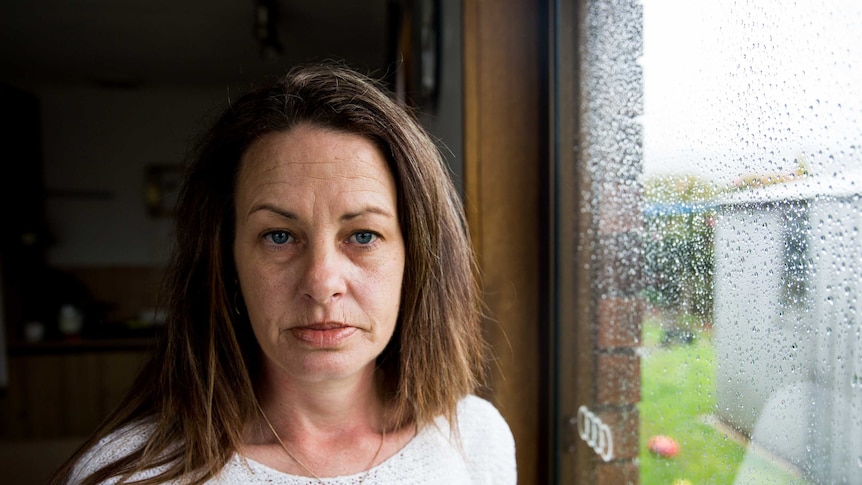 Rebecca Pitchford stands next to a rainy window