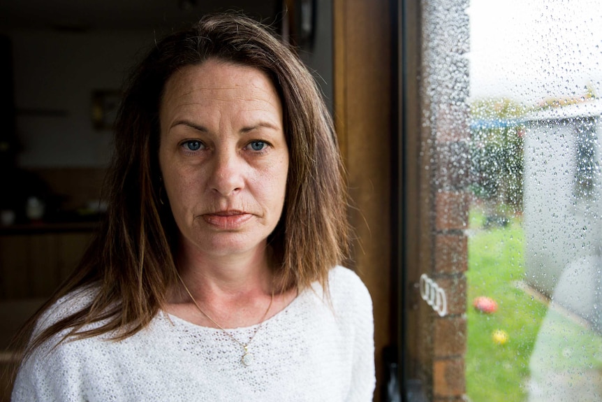 Rebecca Pitchford stands next to a rainy window