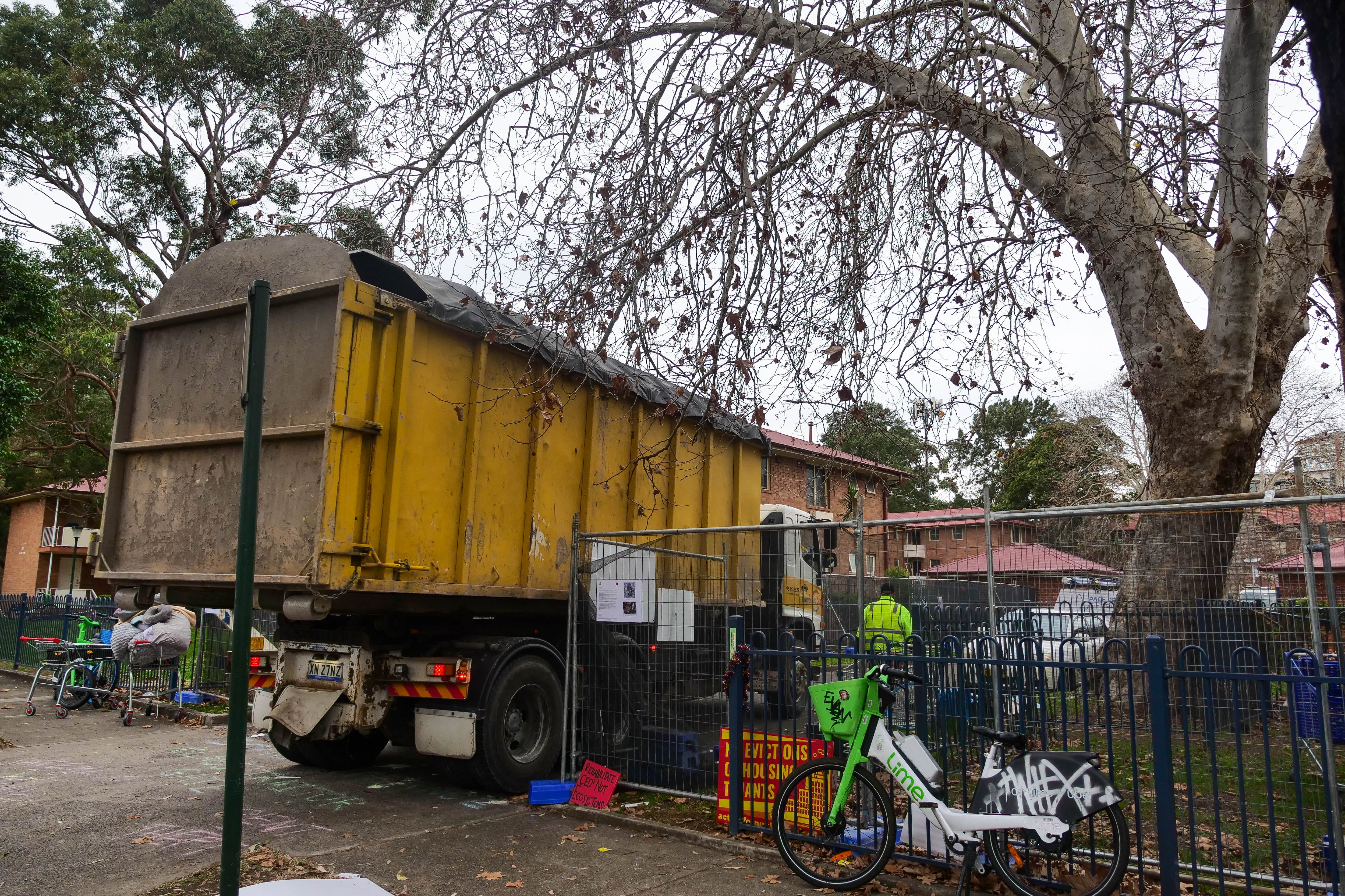 A large yellow truck driving into a parking lot.