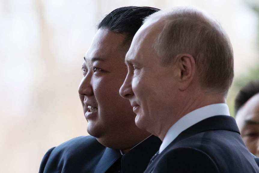 Kim Jong-un smiles as he stands with Vladimir Putin in Vladivostok
