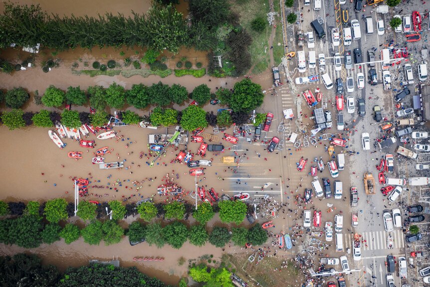 Aerial photo shows rescue workers deploy life rafts for evacuating residents during floods.