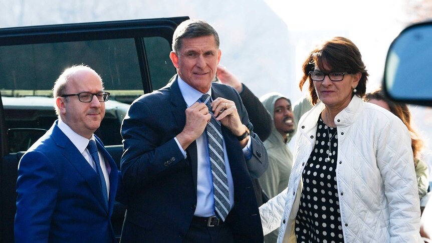 Michael Flynn gets out of a car with a woman and man.