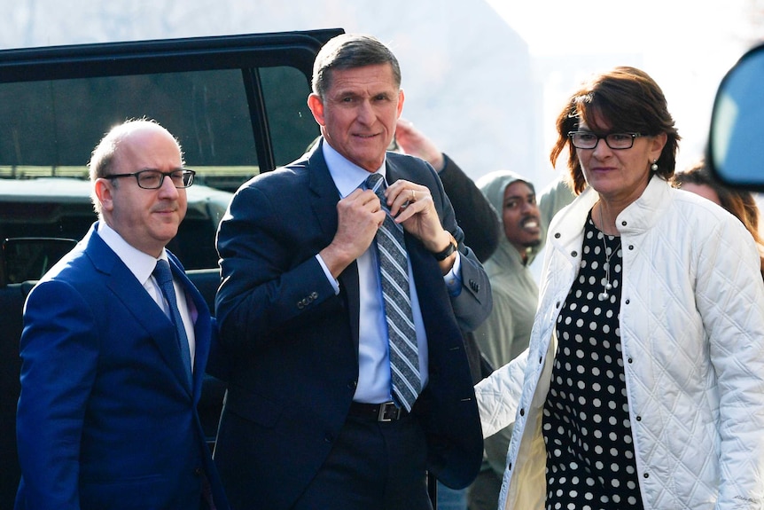 Michael Flynn gets out of a car with a woman and man.