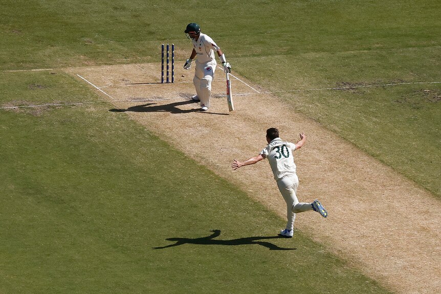 Seen from up high, Australia bowler Pat Cummins runs away in celebration after the wicket of Pakistan batter Babar Azam.