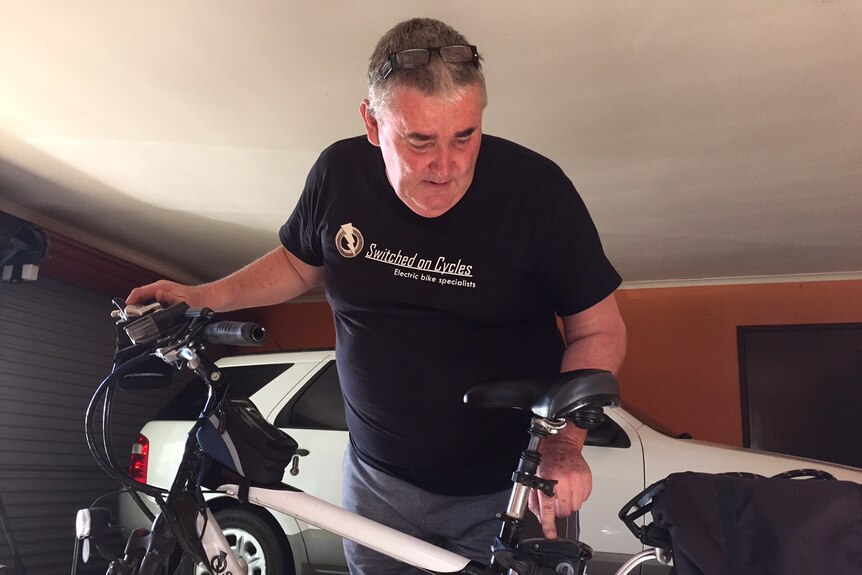 Carl Tallar in his garage with his e-bike.