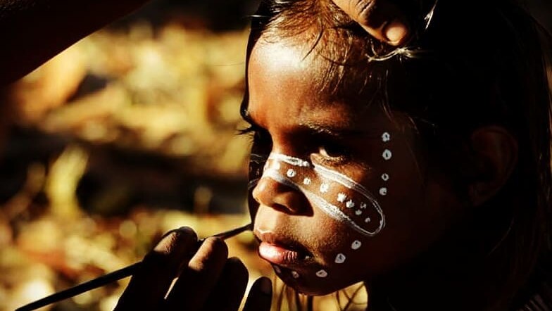 A young child is painted for a traditional ceremony.