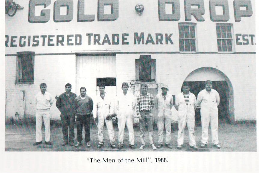 A black and white photo of men outside an old building