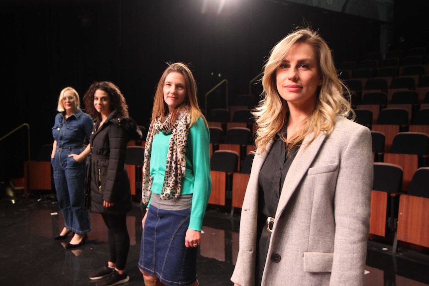 Four women in a line at a theatre